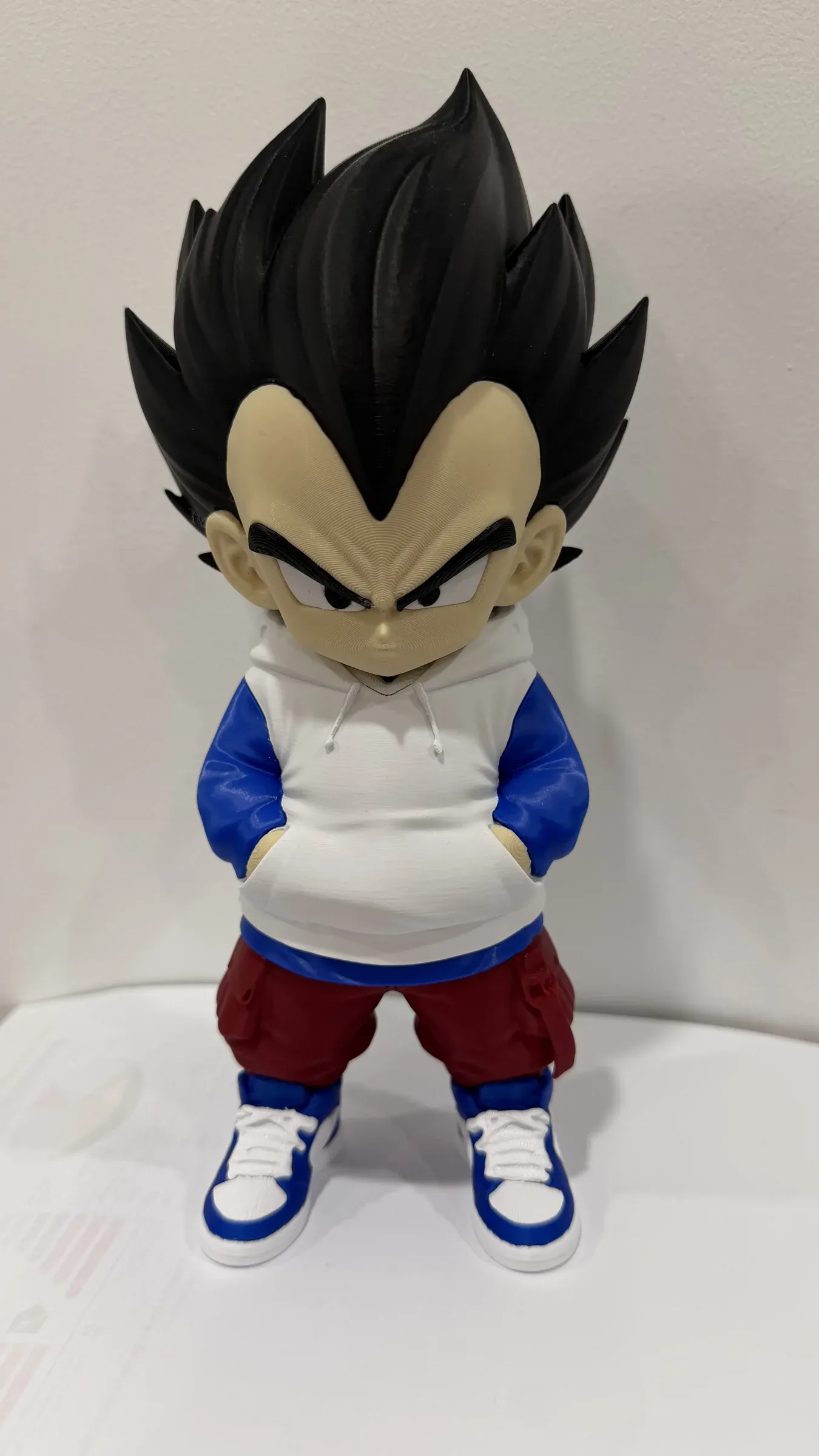Front view of figure with spiky black hair, white hoodie and hands in pockets