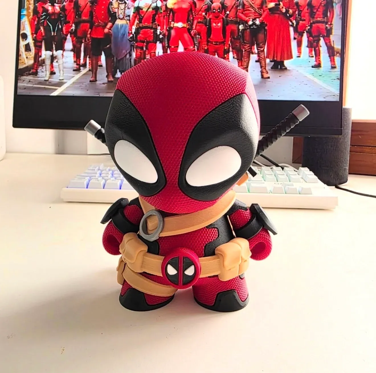 Figura chibi de un mercenario bocazas enmascarado, en rojo y negro, con cinturón beige y una espada a la espalda.